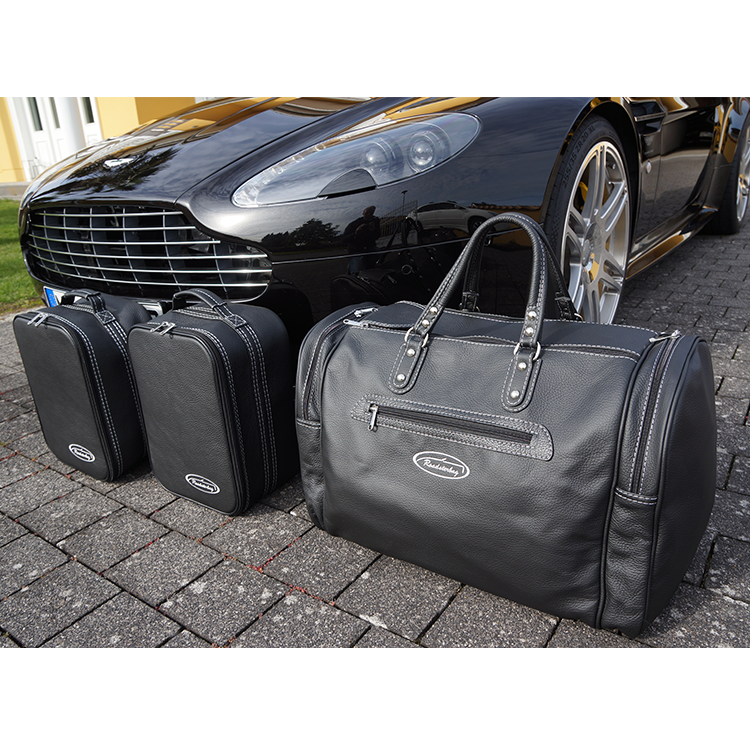 aston martin v8 vantage roadster väskor silvergrå söm framför bil