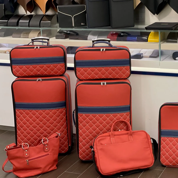 inspiration bagageväskor rött och blått läder vit söm i butik